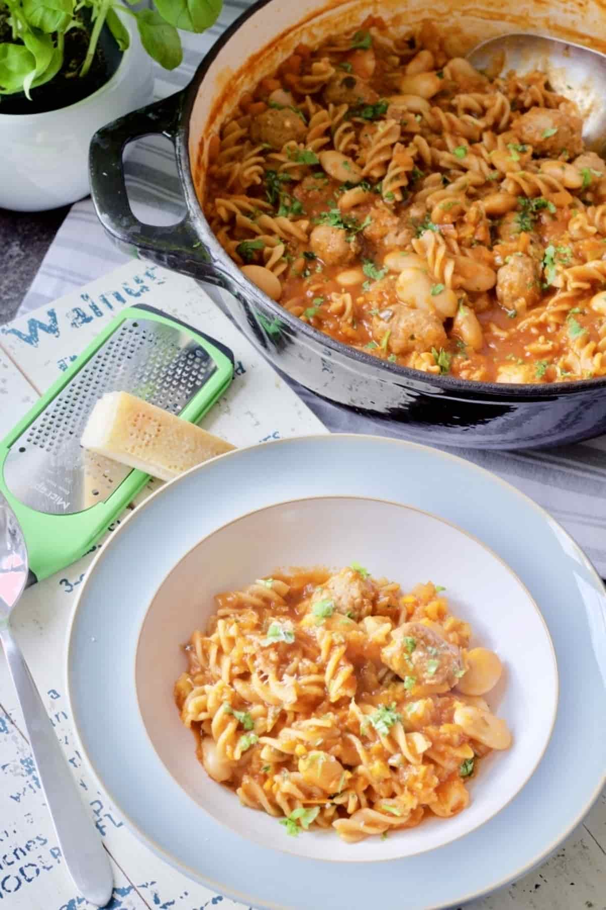 Portion of pasta in a bowl with full pot behind.