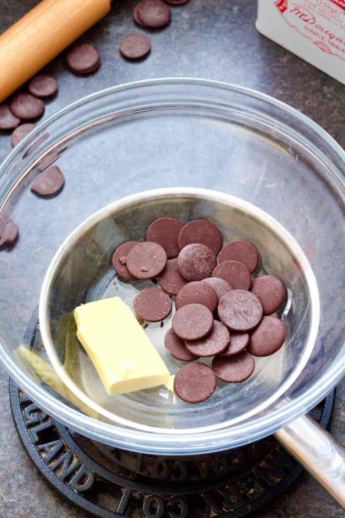 Chocolate buttons & vegan butter in a bowl over a pan.
