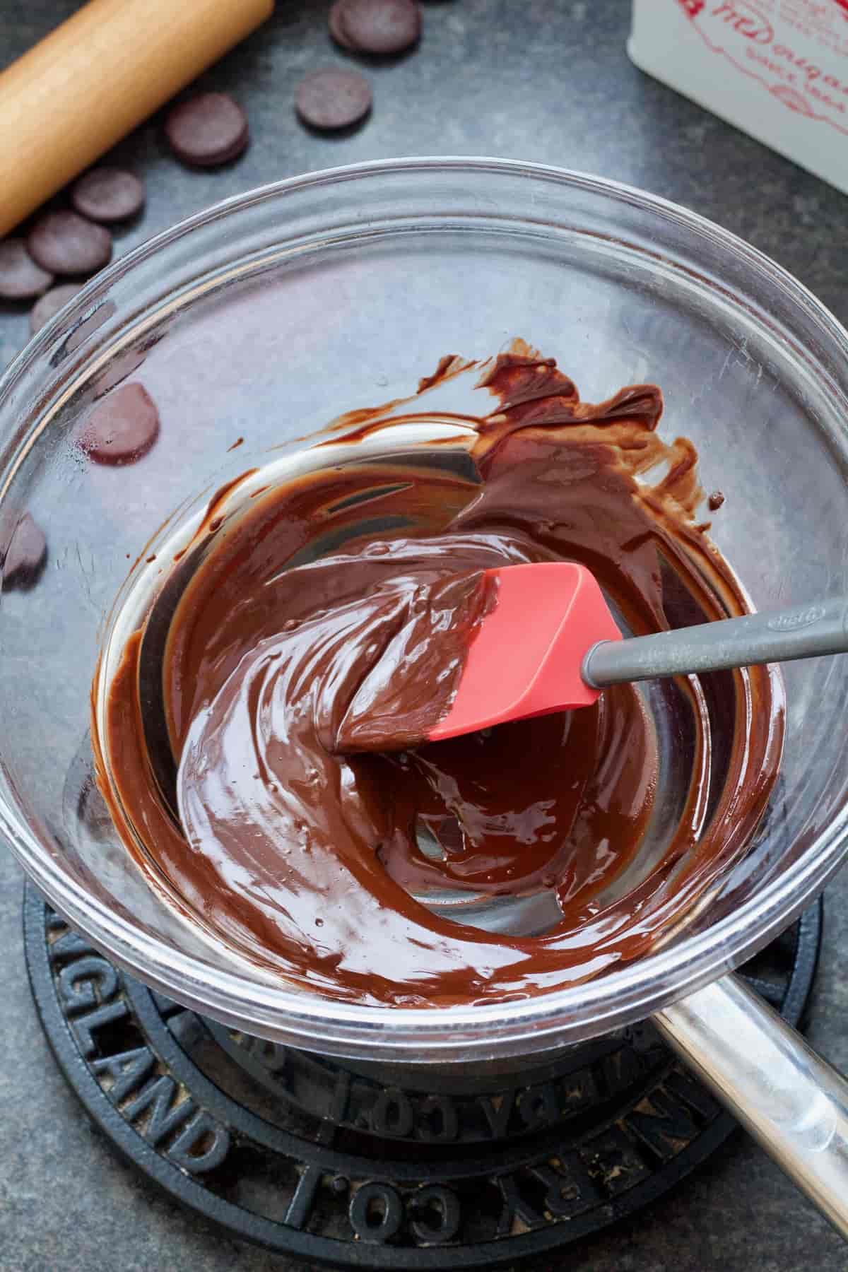 Melted chocolate in a bowl with silicone spatula.