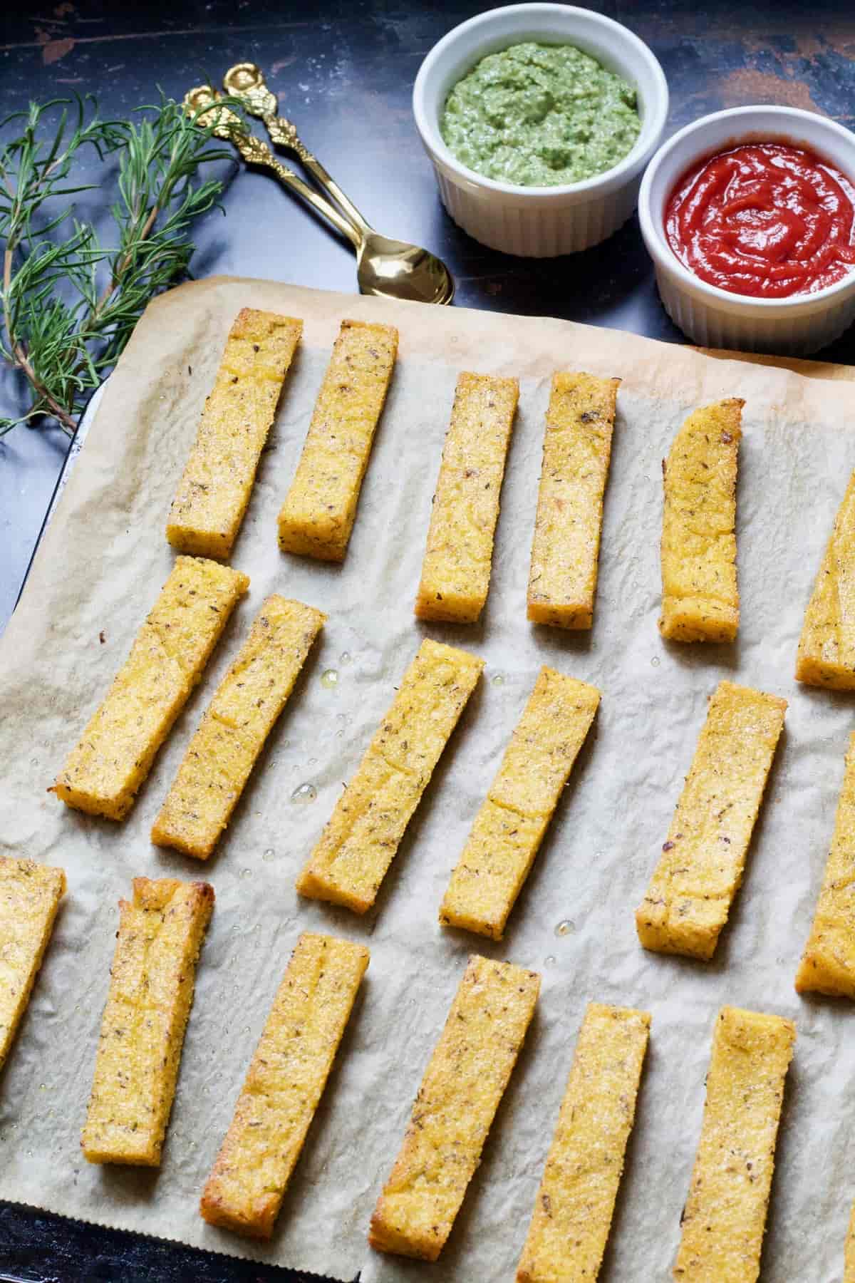 Baked polenta chips on baking tray out of the oven.