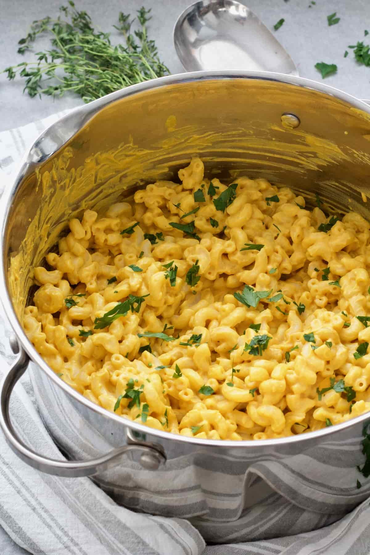 Pot with ready mac and cheese with parsley garnish.