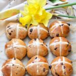 Hot cross buns with daffodils at the top.