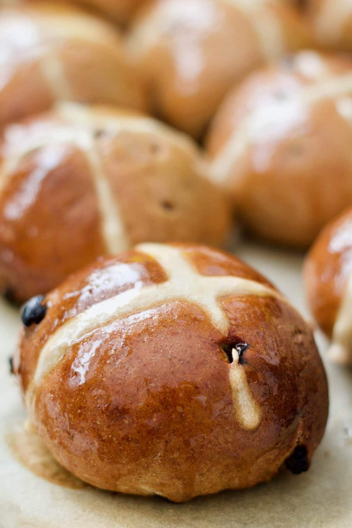 Close up of shiny hot cross bun.