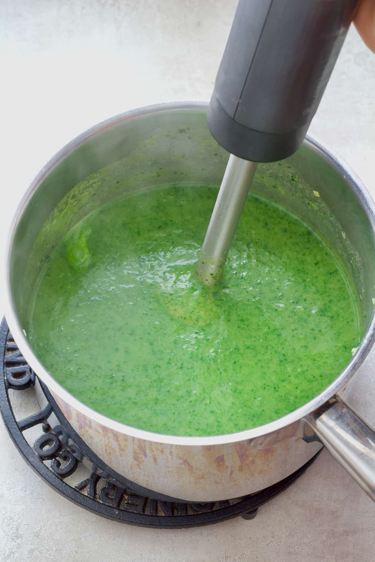 Hand blender blending soup.