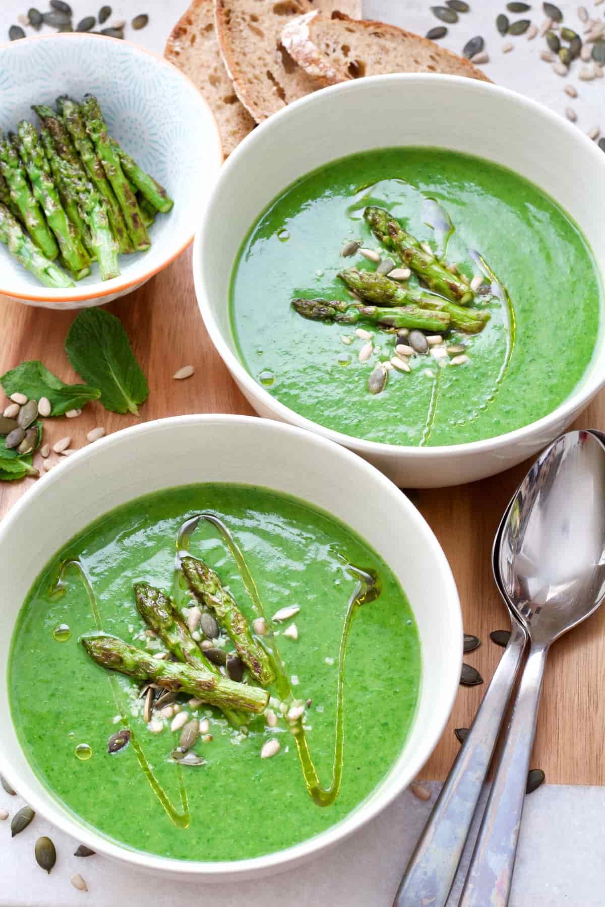 Two bowls of asparagus soup with spinach.