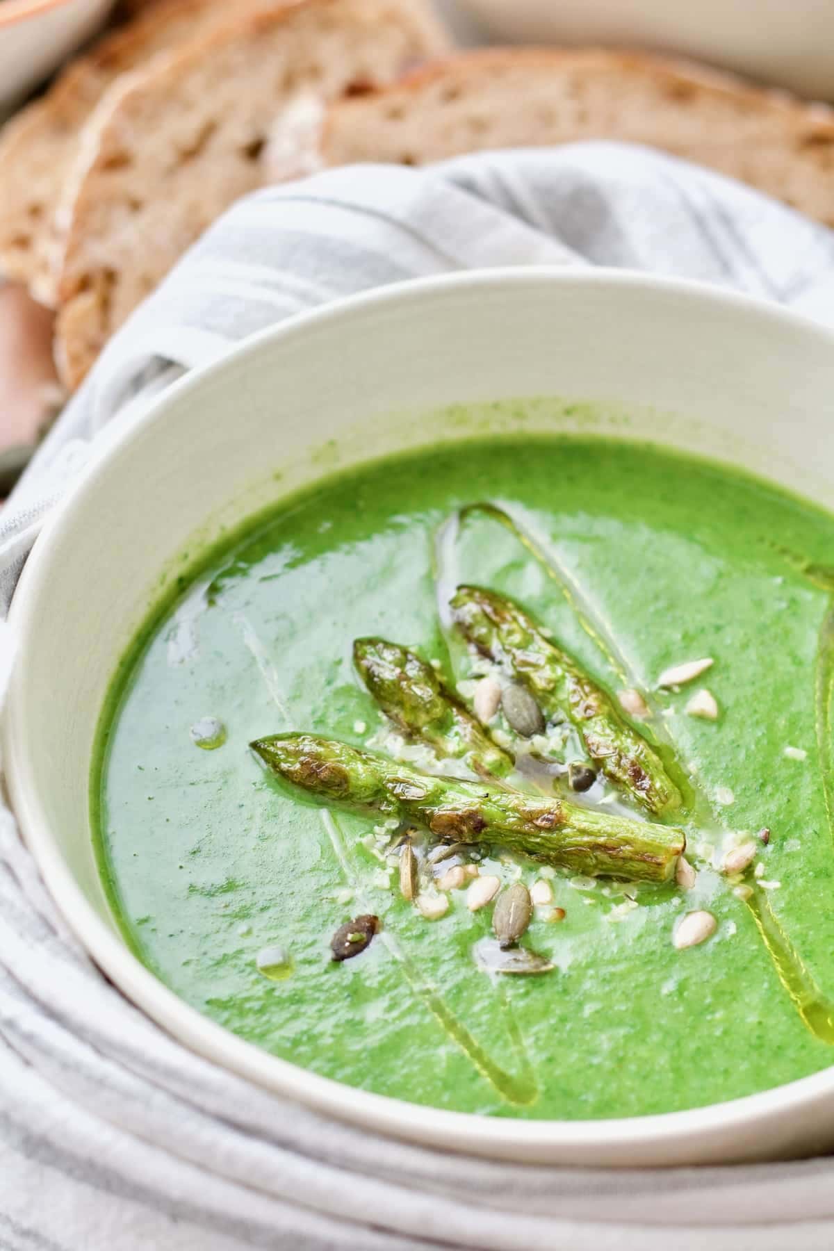 Bowl of asparagus soup with spinach wrapped in towel.