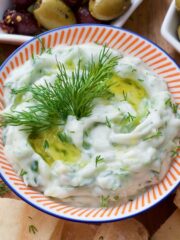 Bowl filled with tzatziki with olive oil and dill.