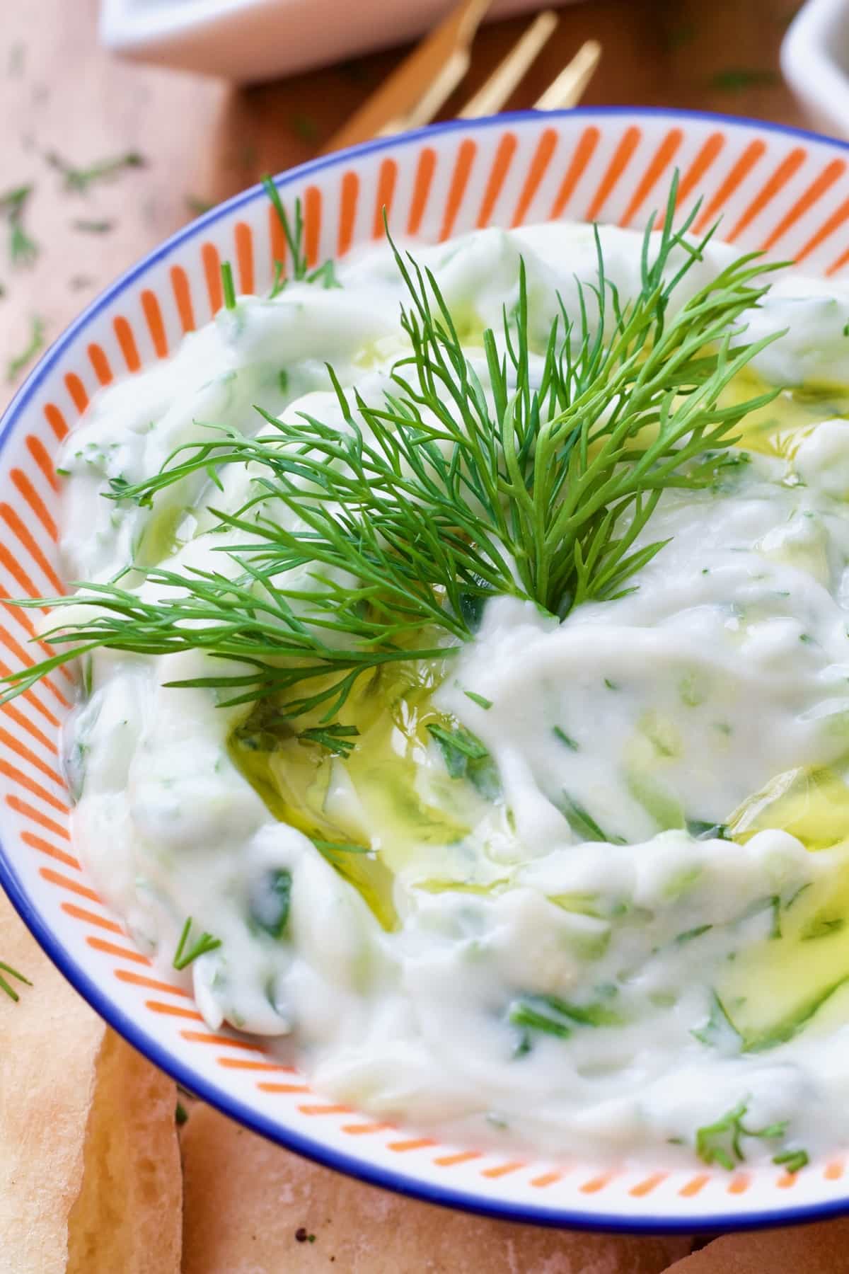 Close up of dill in a bowl with tzatziki.