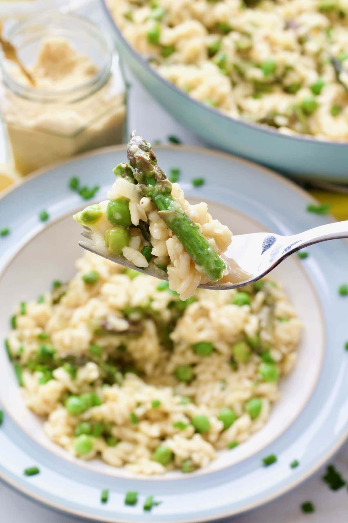 Small portion of pea and asparagus risotto on a fork.