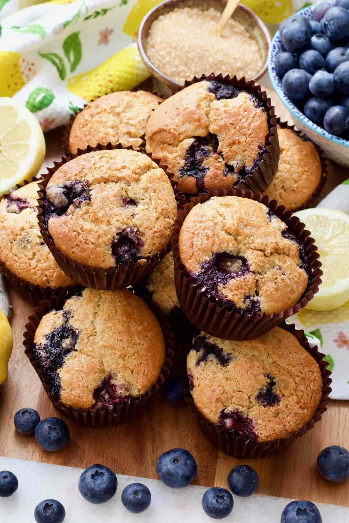 Blueberry muffins piled up on a board.