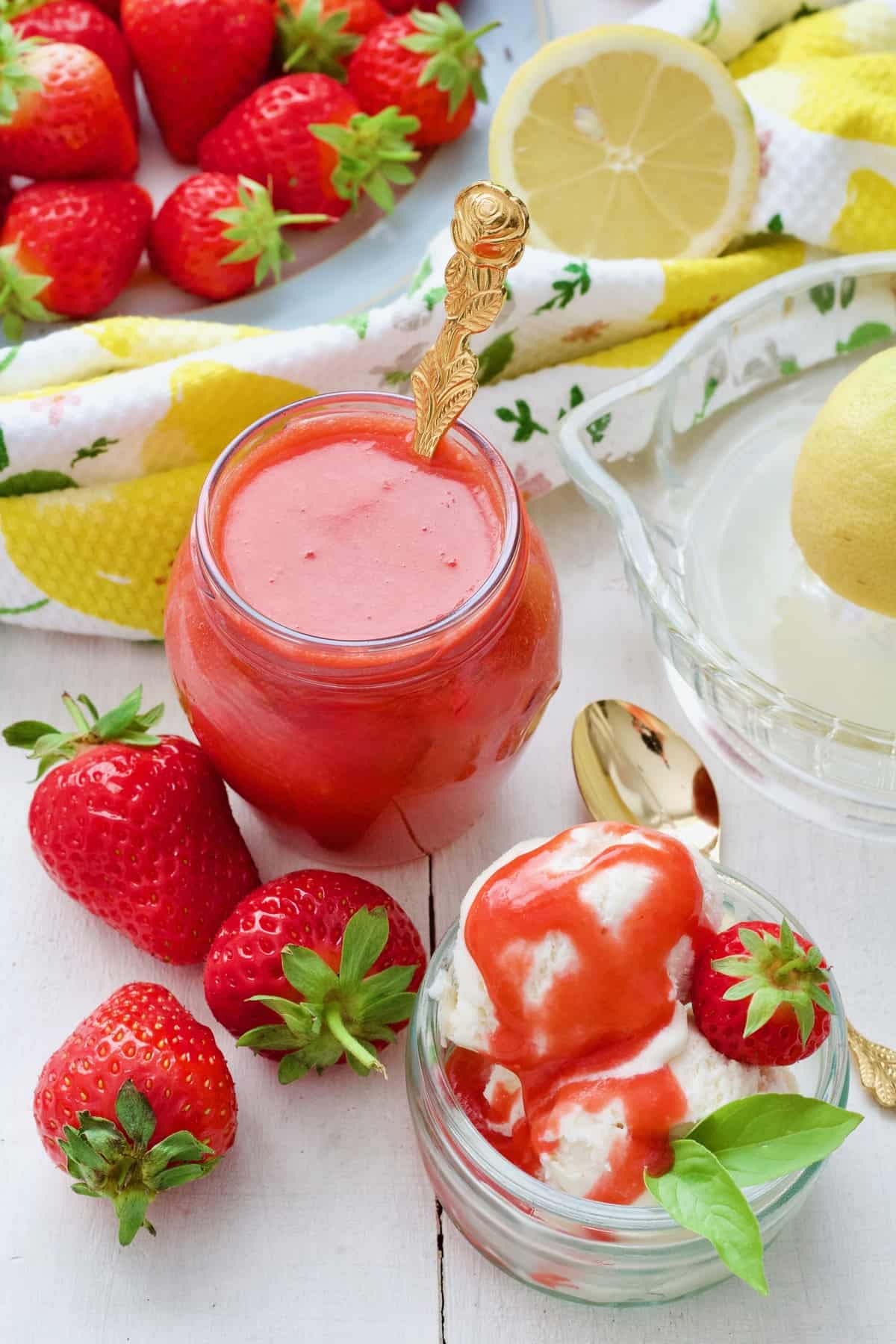 Coulis in a jar, ice cream and fresh strawberries.