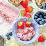 Breakfast spread, bowl with strawberry overnight oats & 2 strawberries.