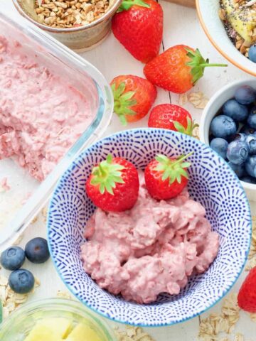 Breakfast spread, bowl with strawberry overnight oats & 2 strawberries.