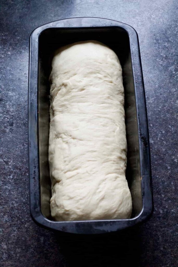 Shaped bread loaf in a tin before proving.