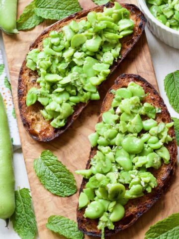 Close up of two broad bean bruschettas.