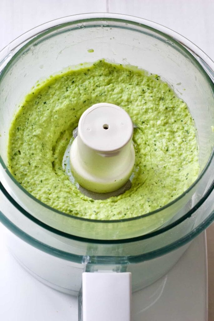 Pureed broad bean dip in food processor.