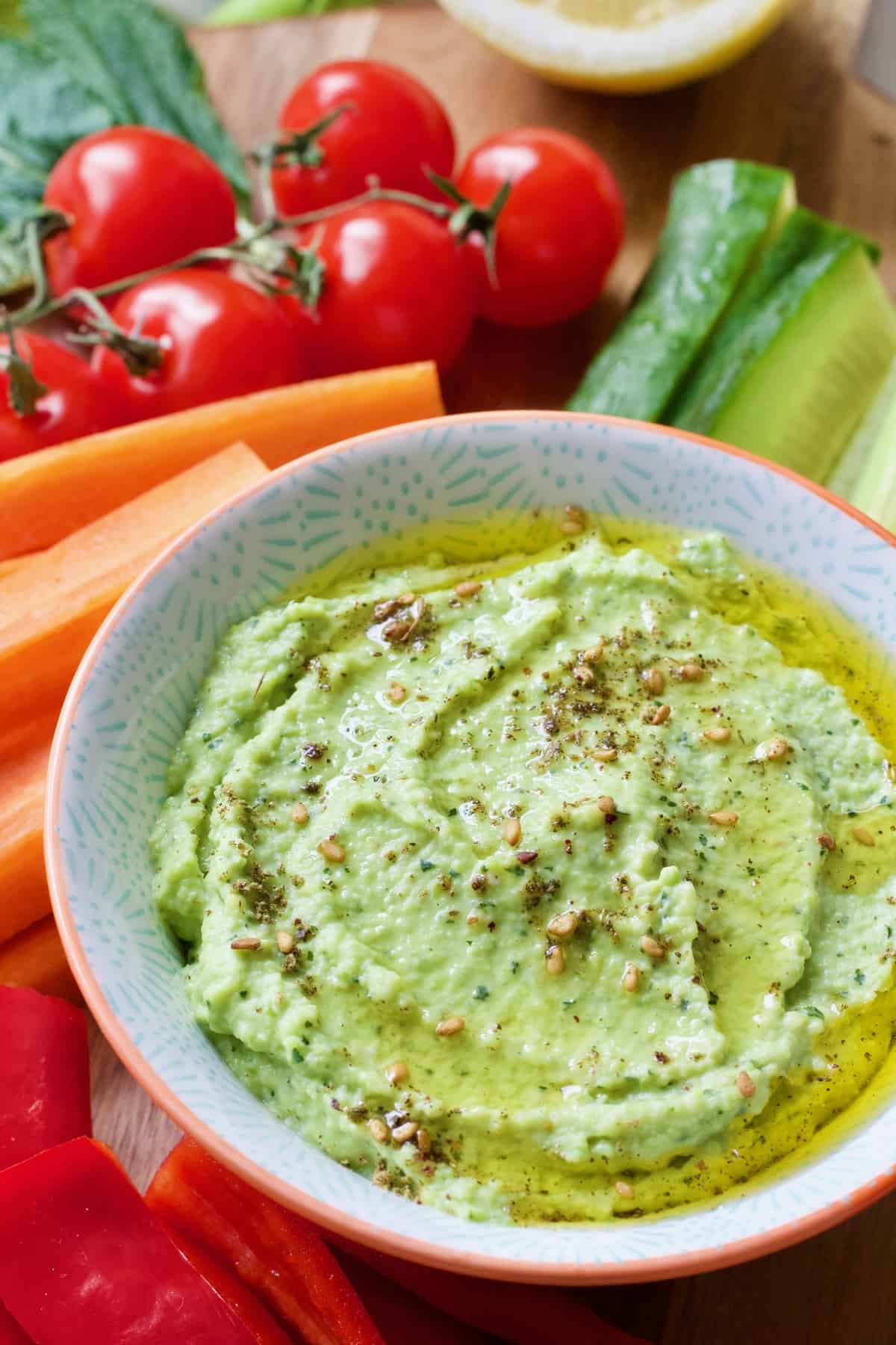 Broad bean dip in a bowl with olive oil and zaatar sprinkle.