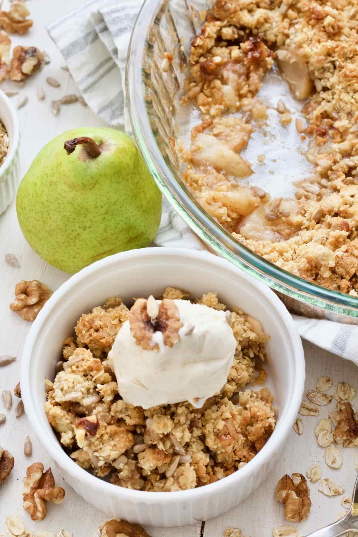 Pear crumble served in a bowl with ice cream.