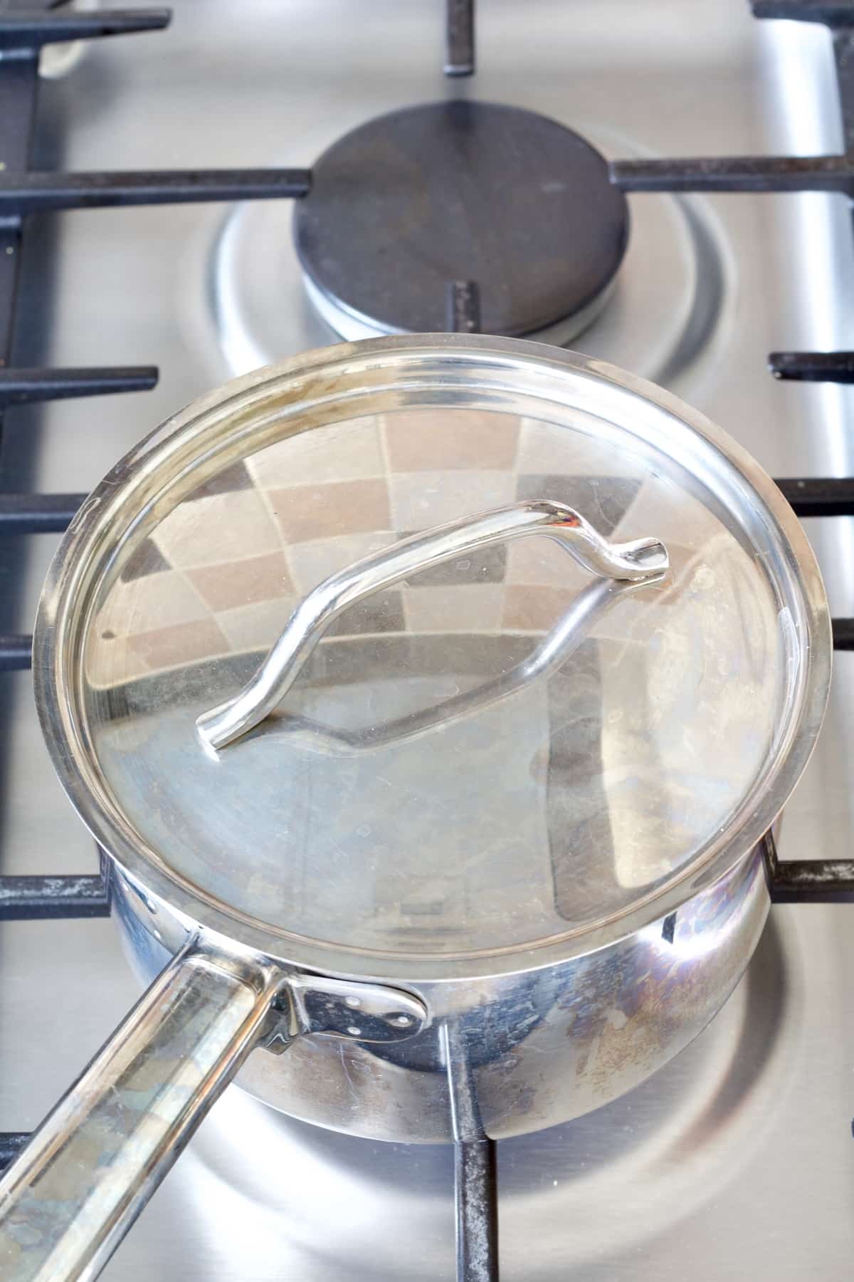 Lidded pan on top of a stove.