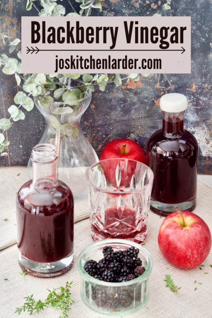 Bottles with vinegar, bowl of blackberries, apples.