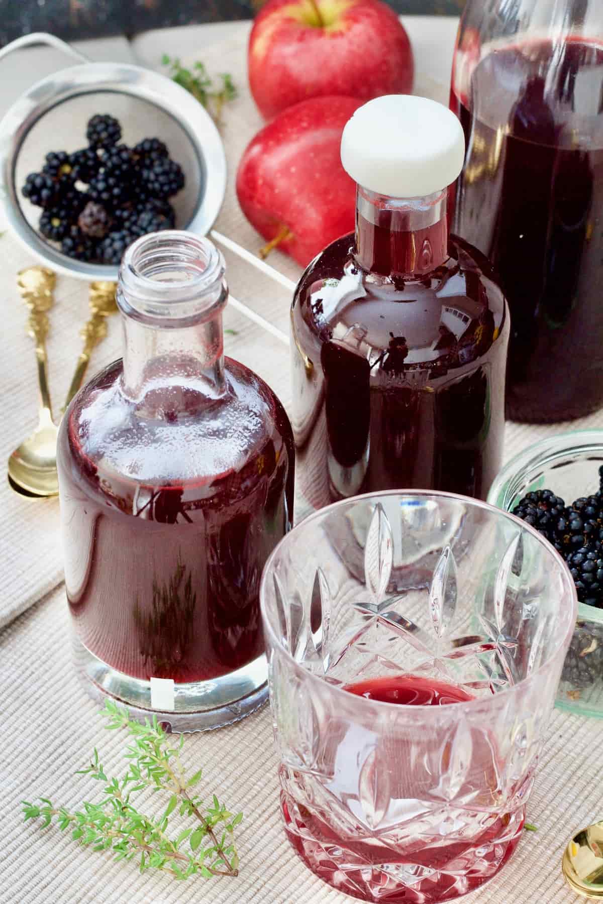 Two bottles of blackberry vinegar, small tumbler.