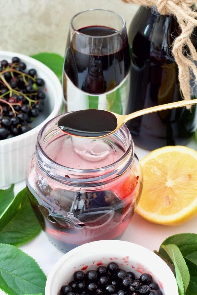 Spoonful of elderberry syrup over the jar.