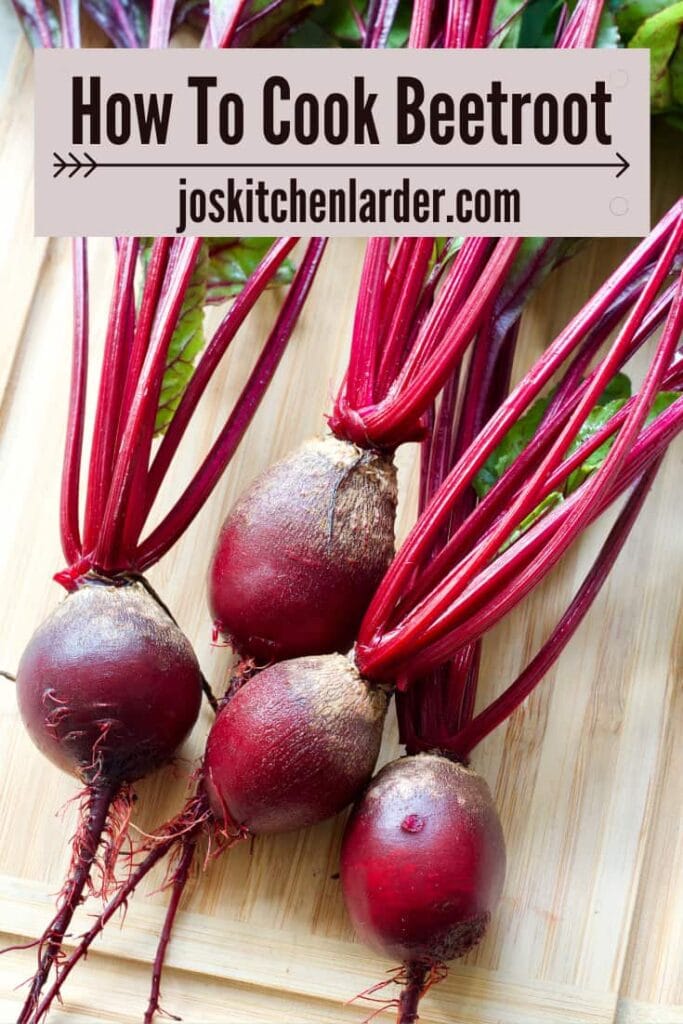 Young beets with greens on a board.