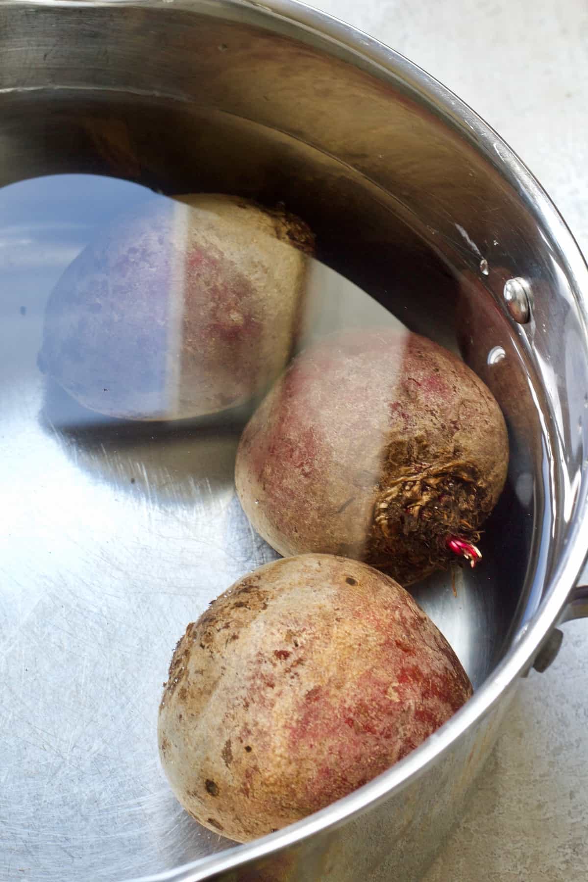 Beetroot in a pan filled with water.