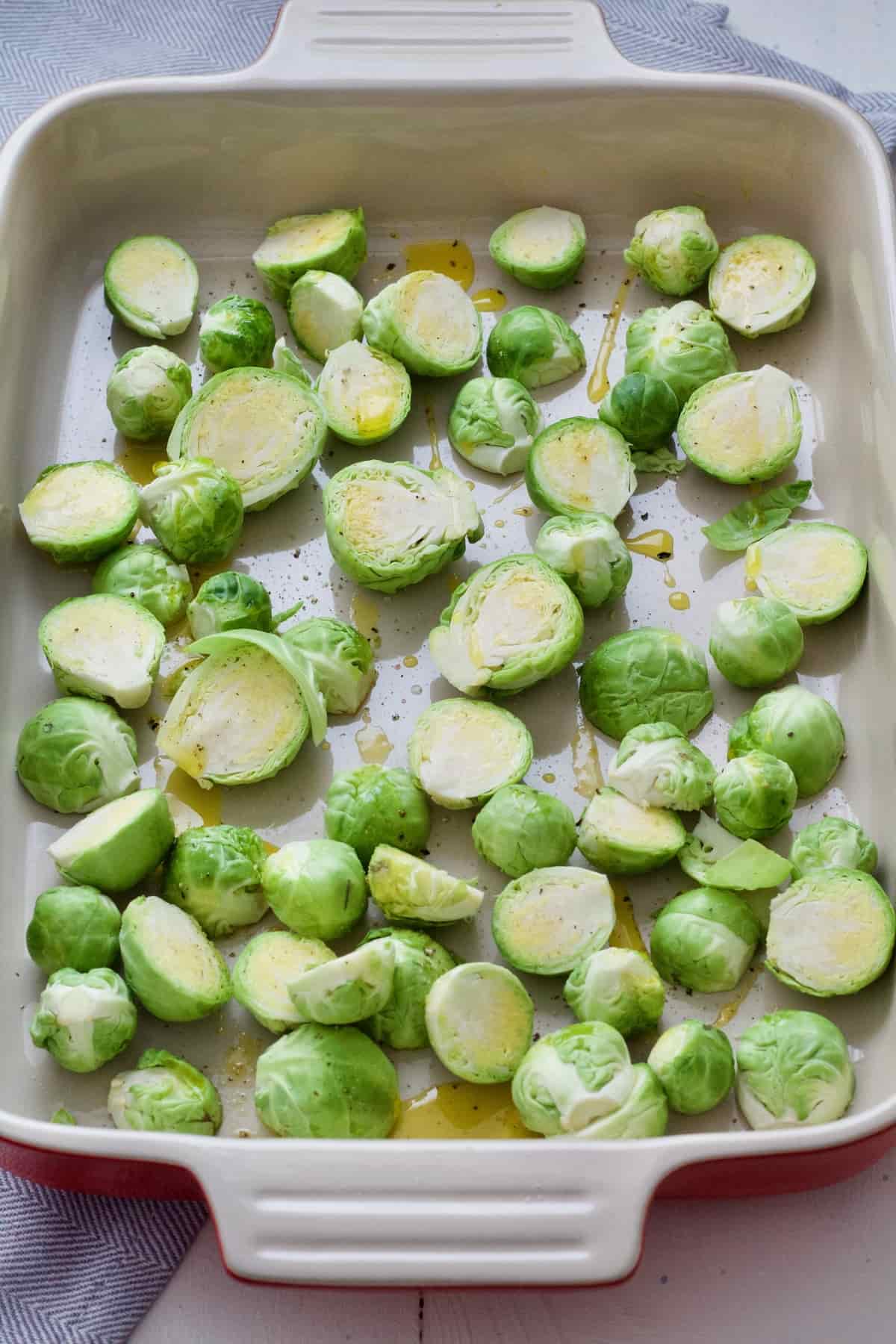 Prepared Brussels sprouts in a baking dish ready for roasting.