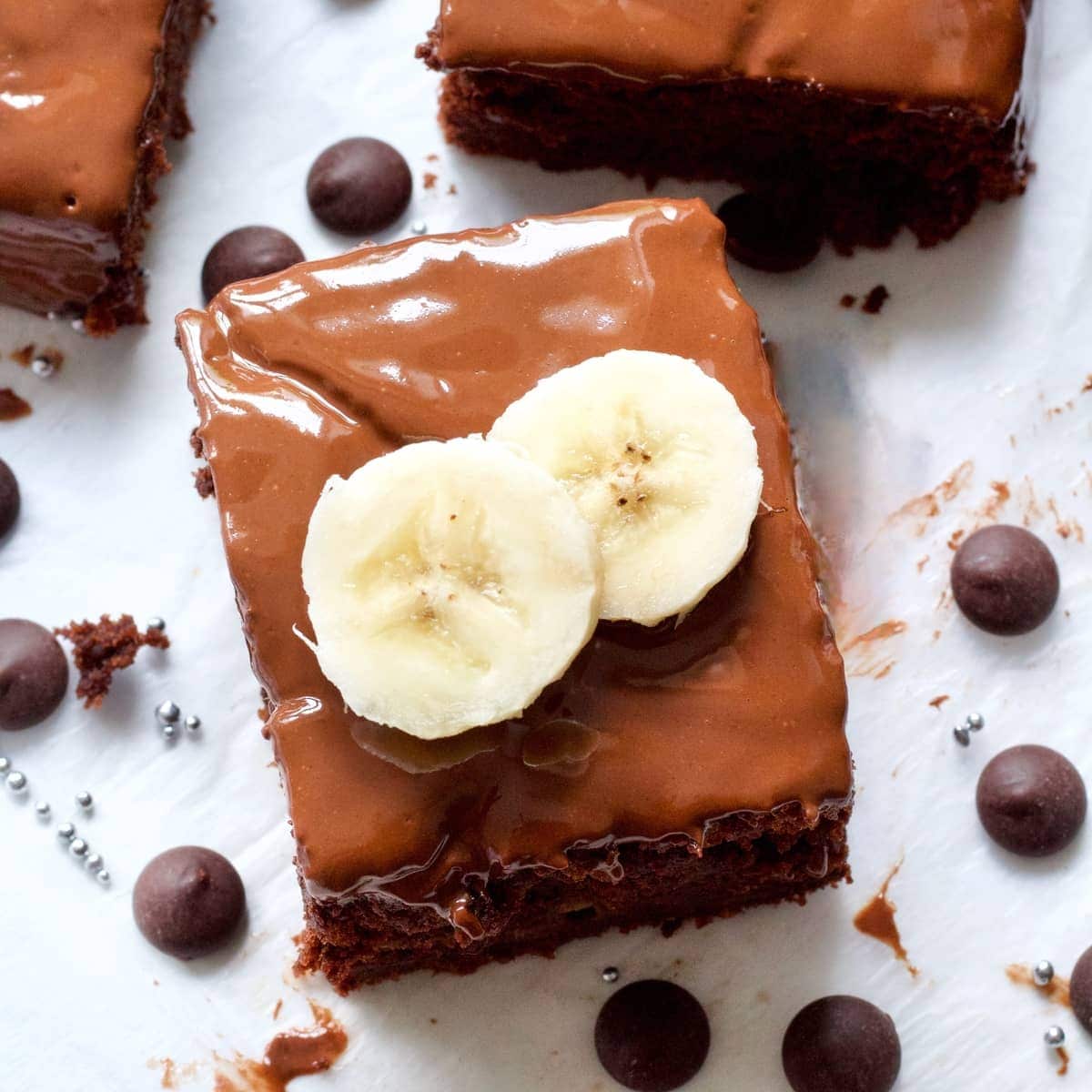 Portion of vegan chocolate banana cake topped with banana slices.