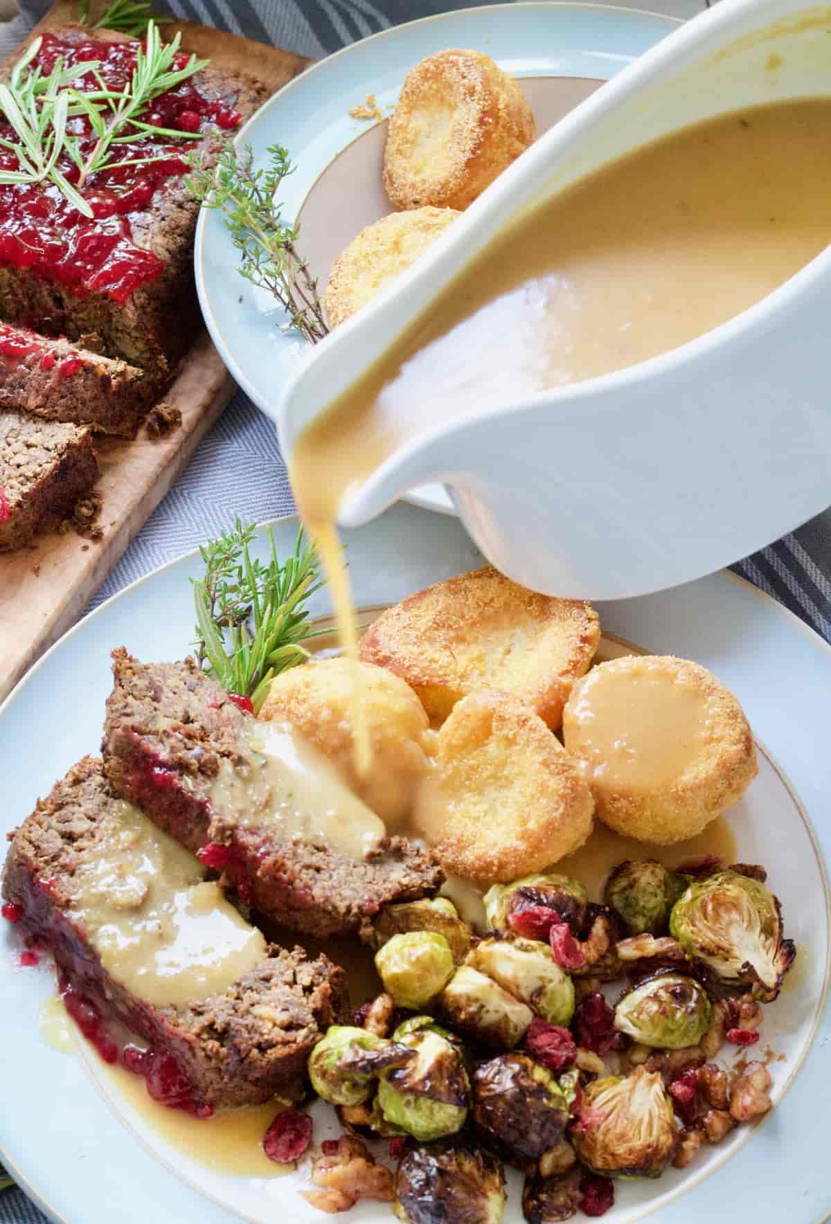 Vegan gravy being poured over vegan roast dinner.