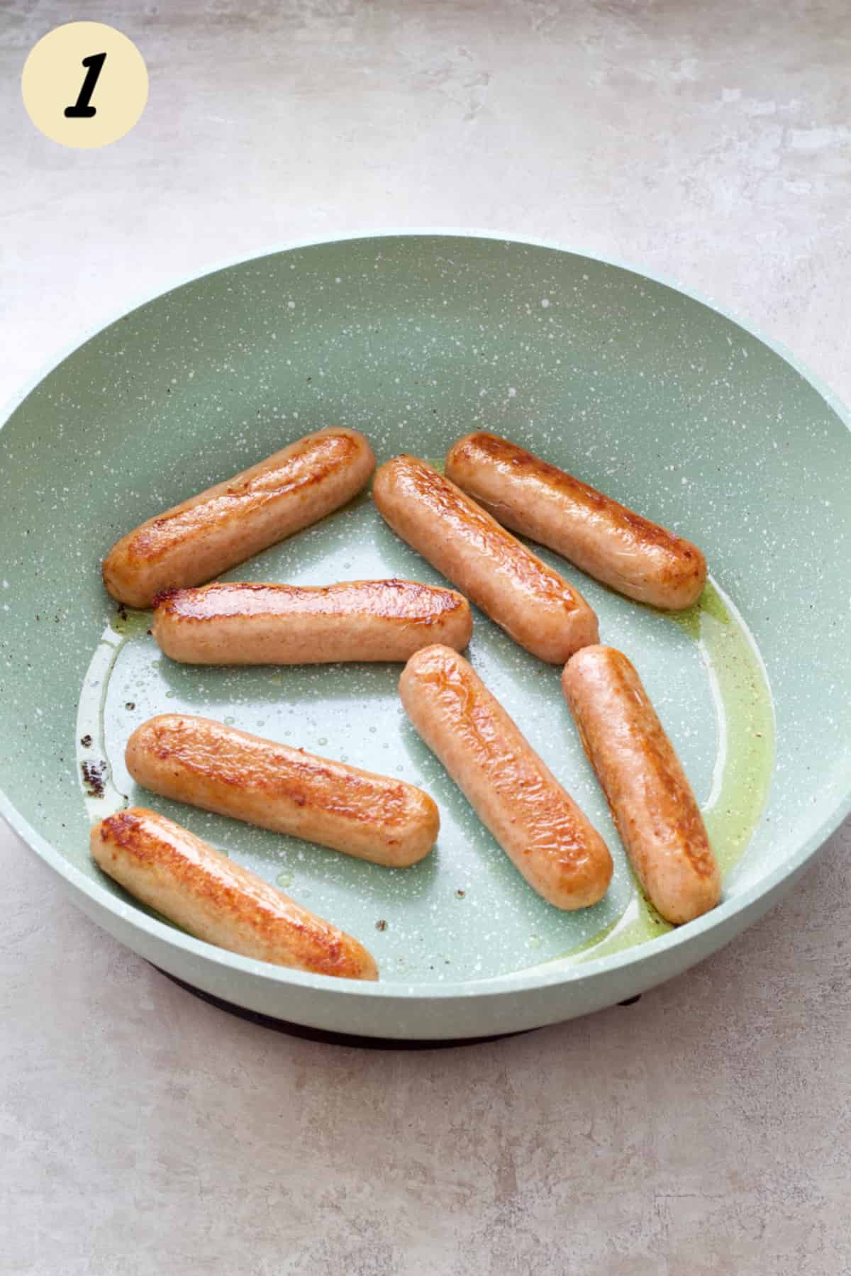 Vegan sausages in a frying pan.
