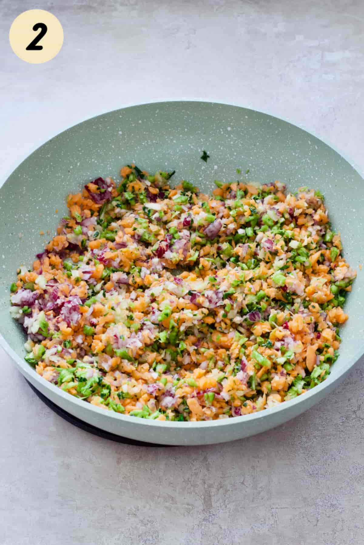 Finely chopped veggies in a frying pan.