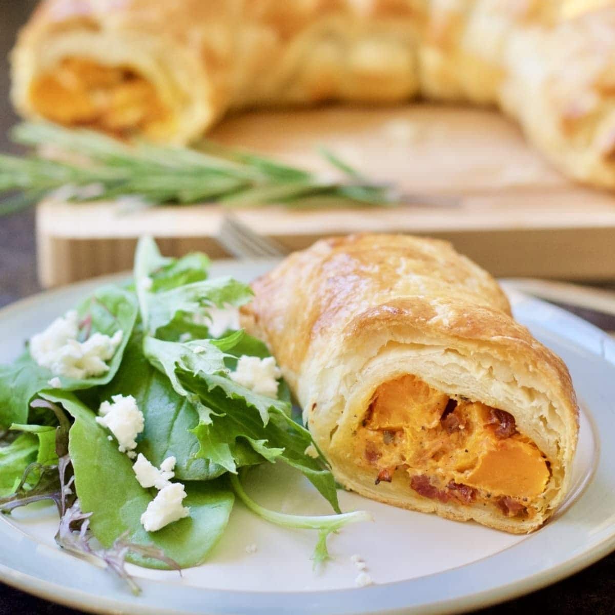 Close up of portion of squash wellington with side salad.