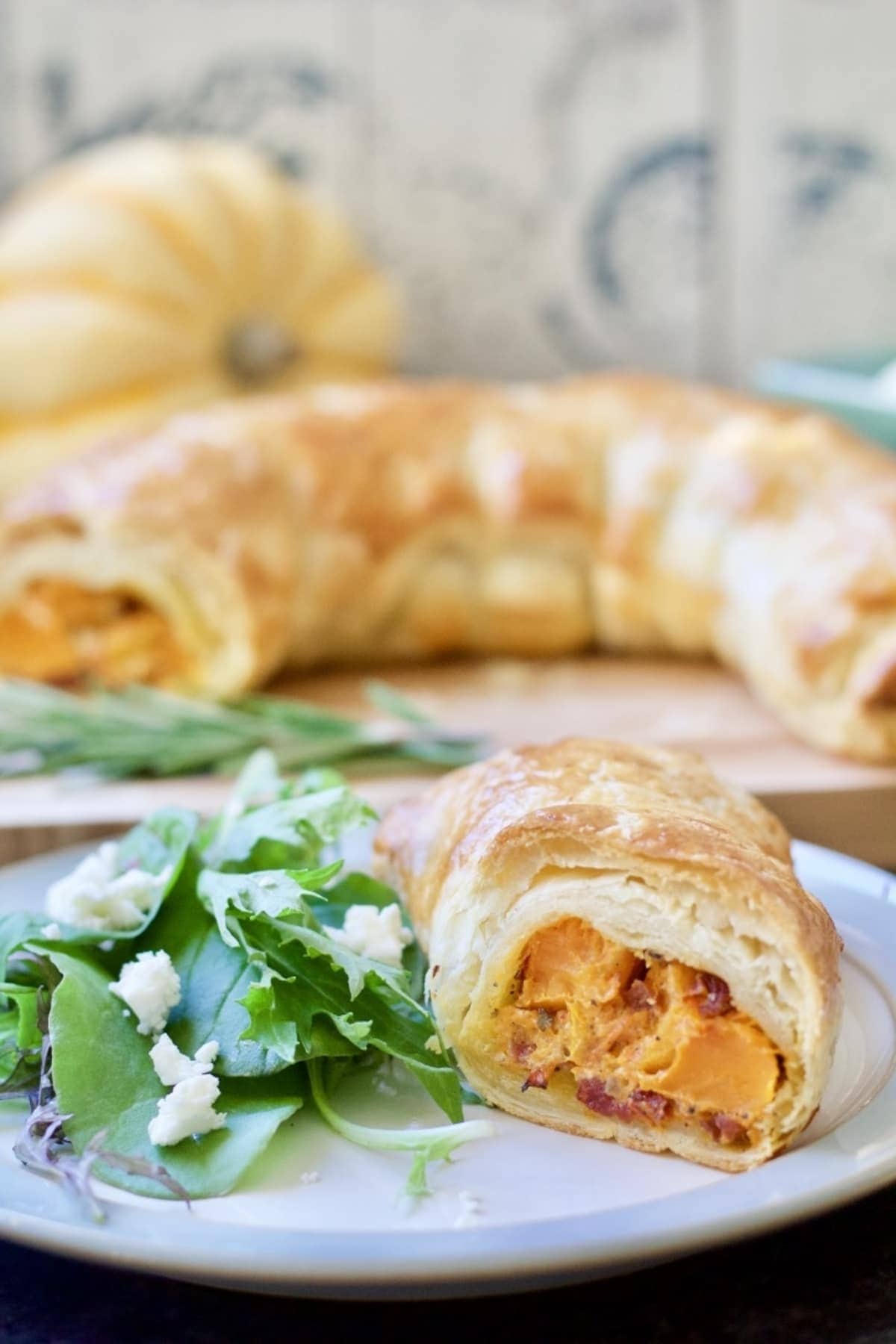 Plated up portion of vegan squash wellington with side salad.