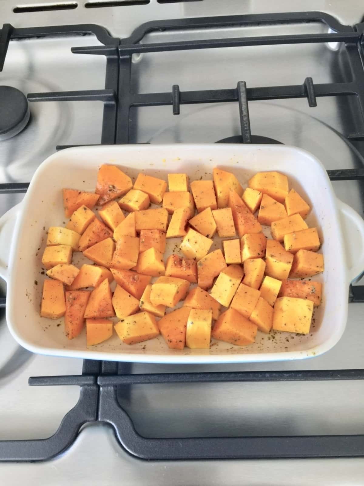 Chunks of butternut squash in a dish ready for roasting.