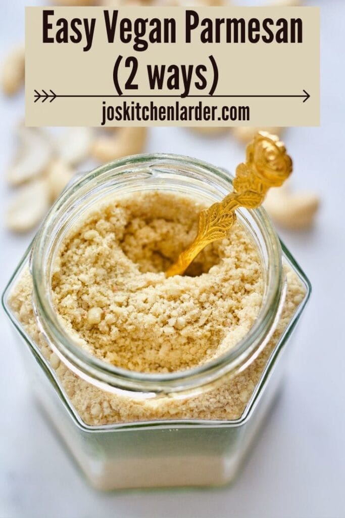 Close up of jar with vegan cashew nuts parmesan with spoon in it.