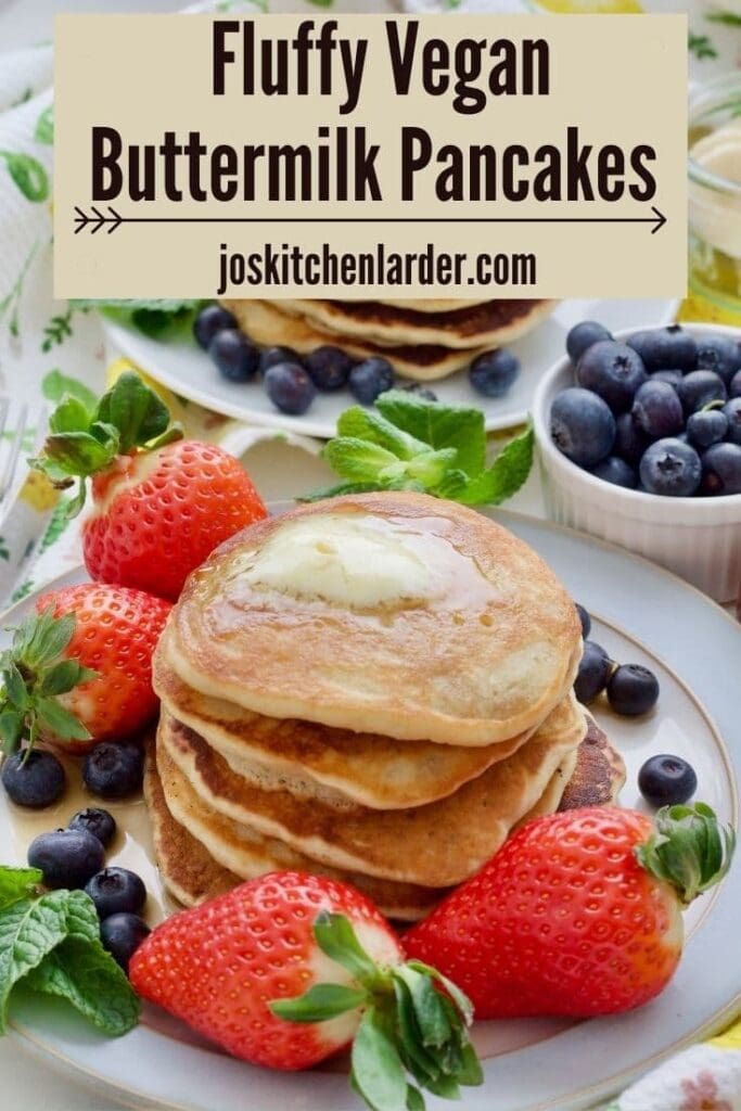 Stack of fluffy vegan buttermilk pancakes with vegan butter and berries.