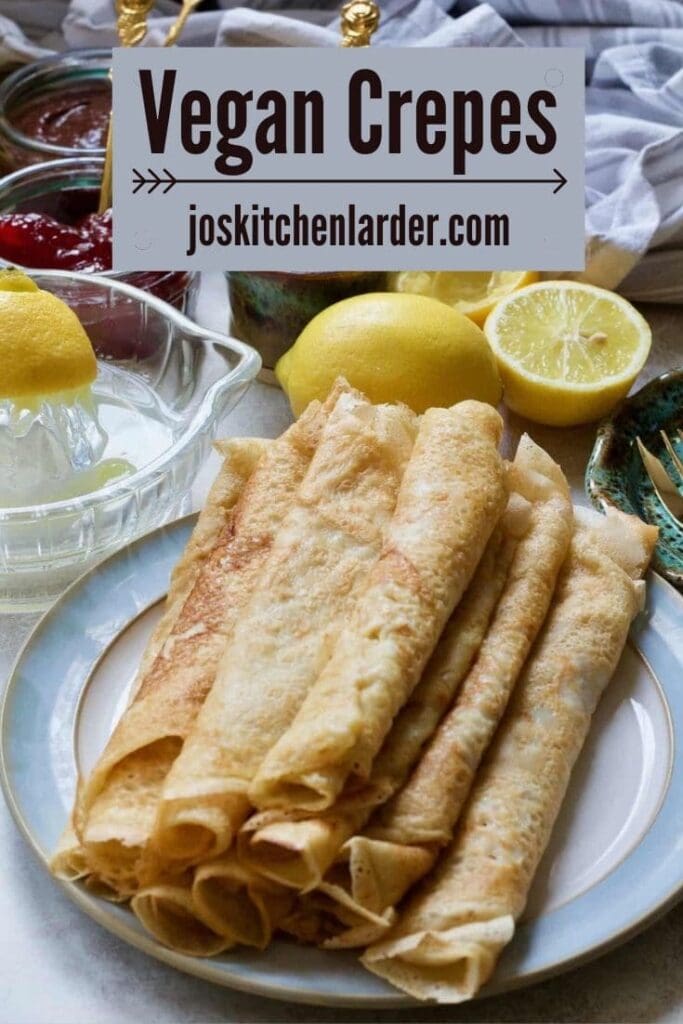 Rolled up vegan crepes on a plate, lemons.