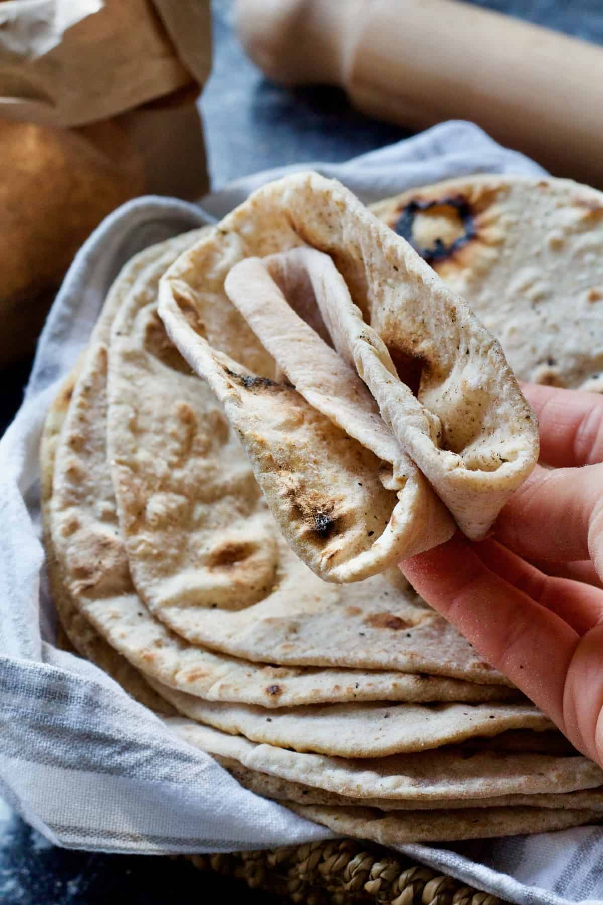 Hand holding folded chapati.