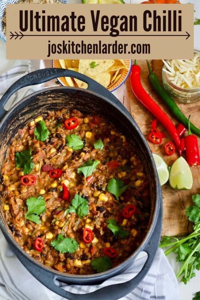 Large pot with vegan chilli topped with chilli slices and coriander.
