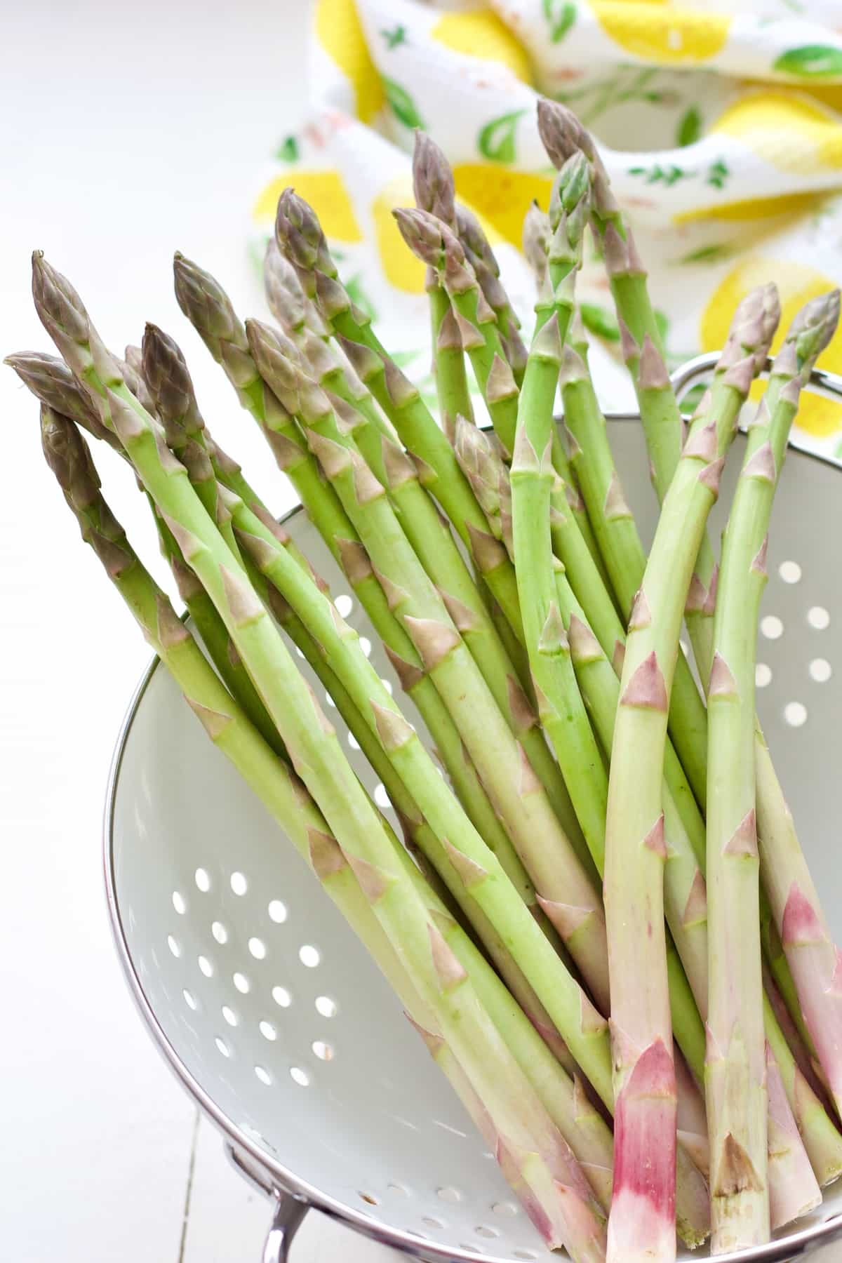 Raw asparagus spears in a colander.