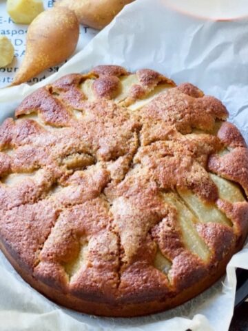 Pear and fresh ginger cake on a piece of parchment.