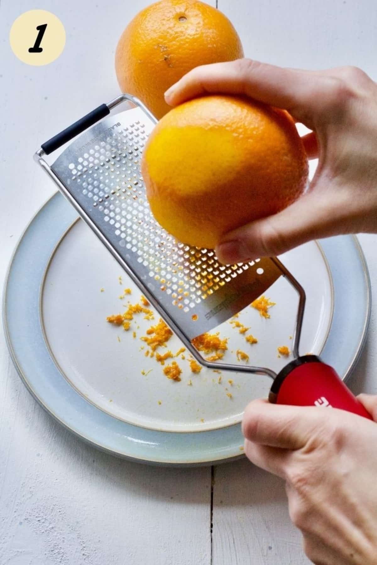 Grating an orange onto a plate.