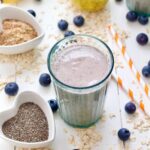 Close up of glass with oat milk smoothie and bowl with chia seeds.