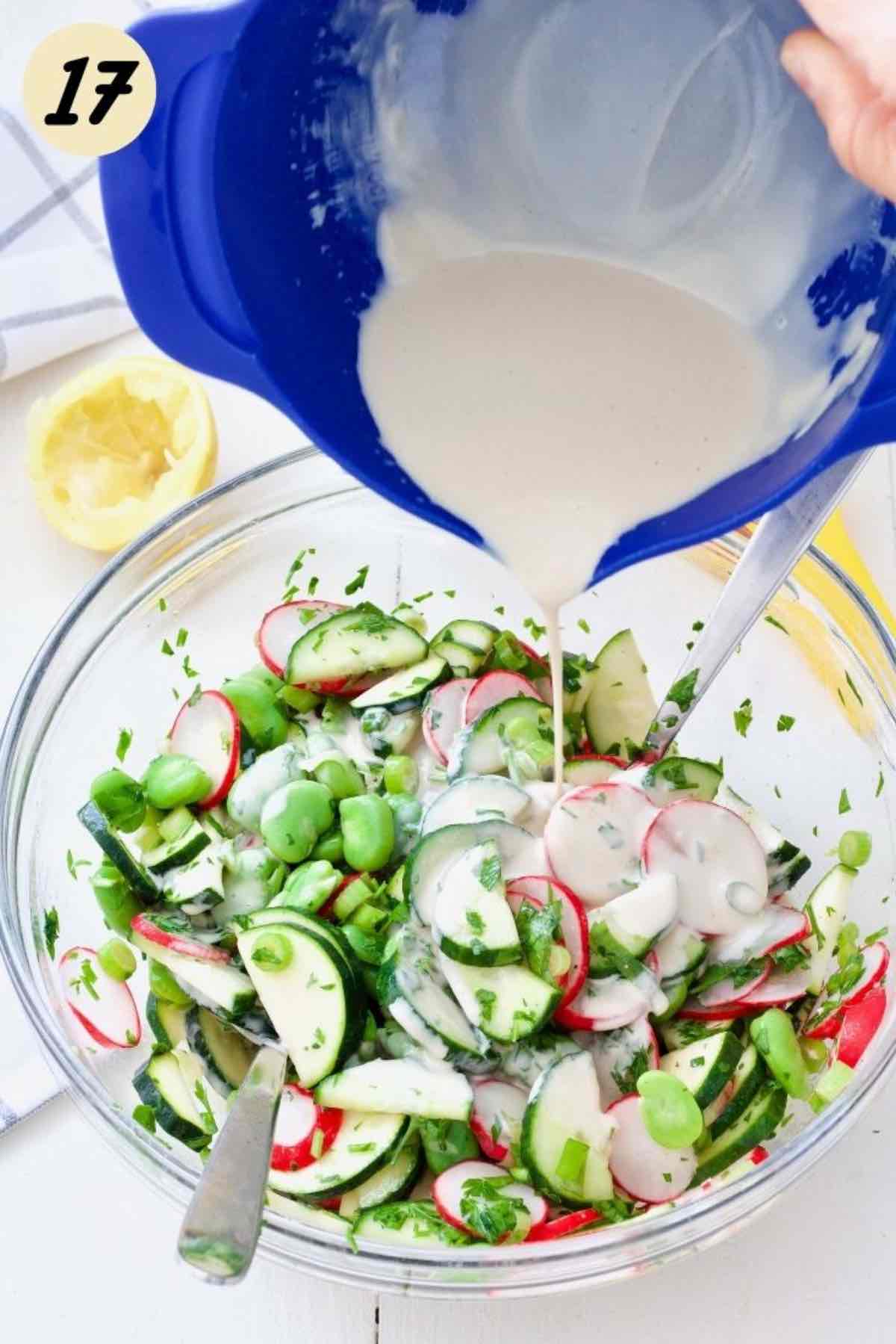 Pouring tahini dressing over the salad.