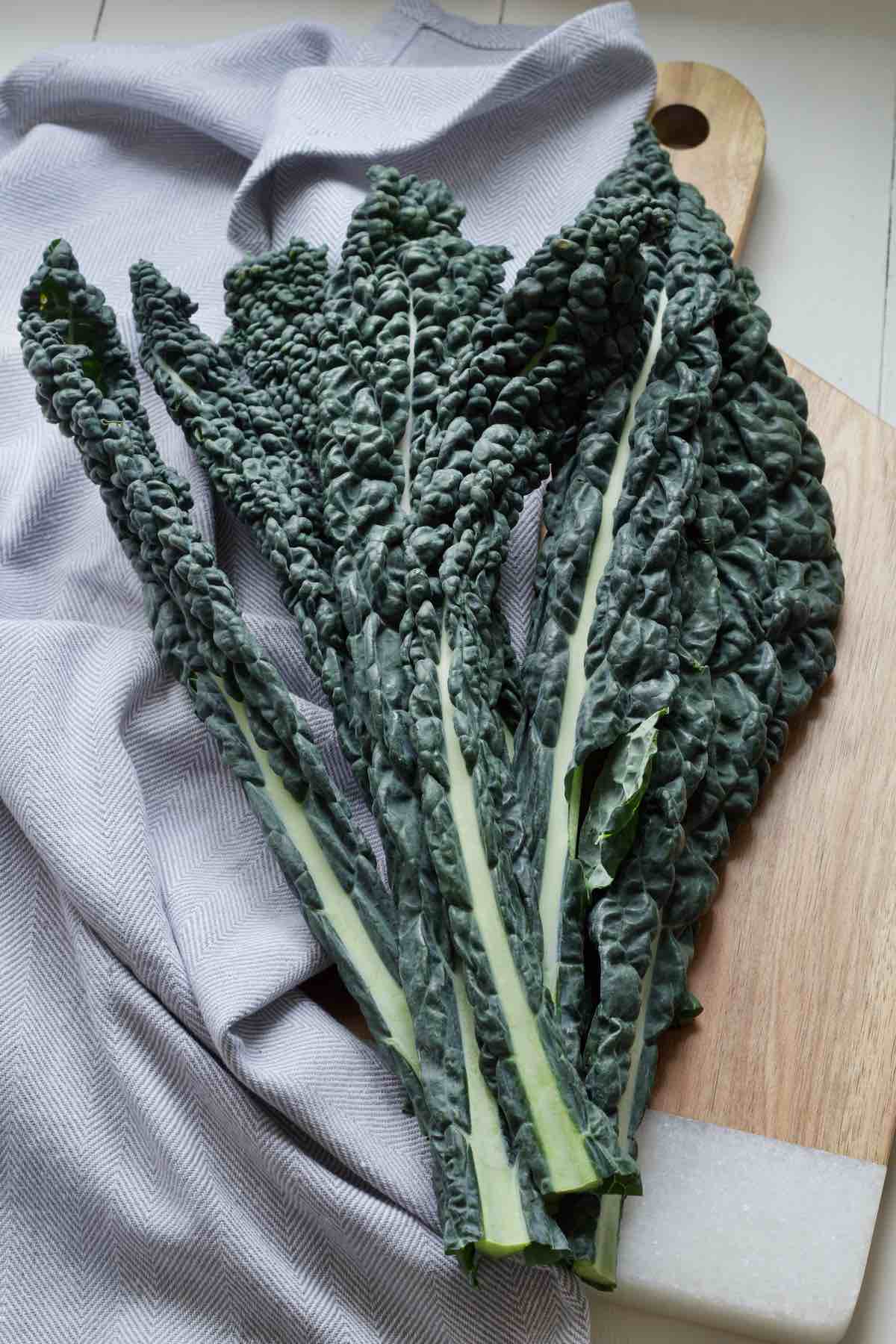 Bunch of cavolo nero leaves on a board.