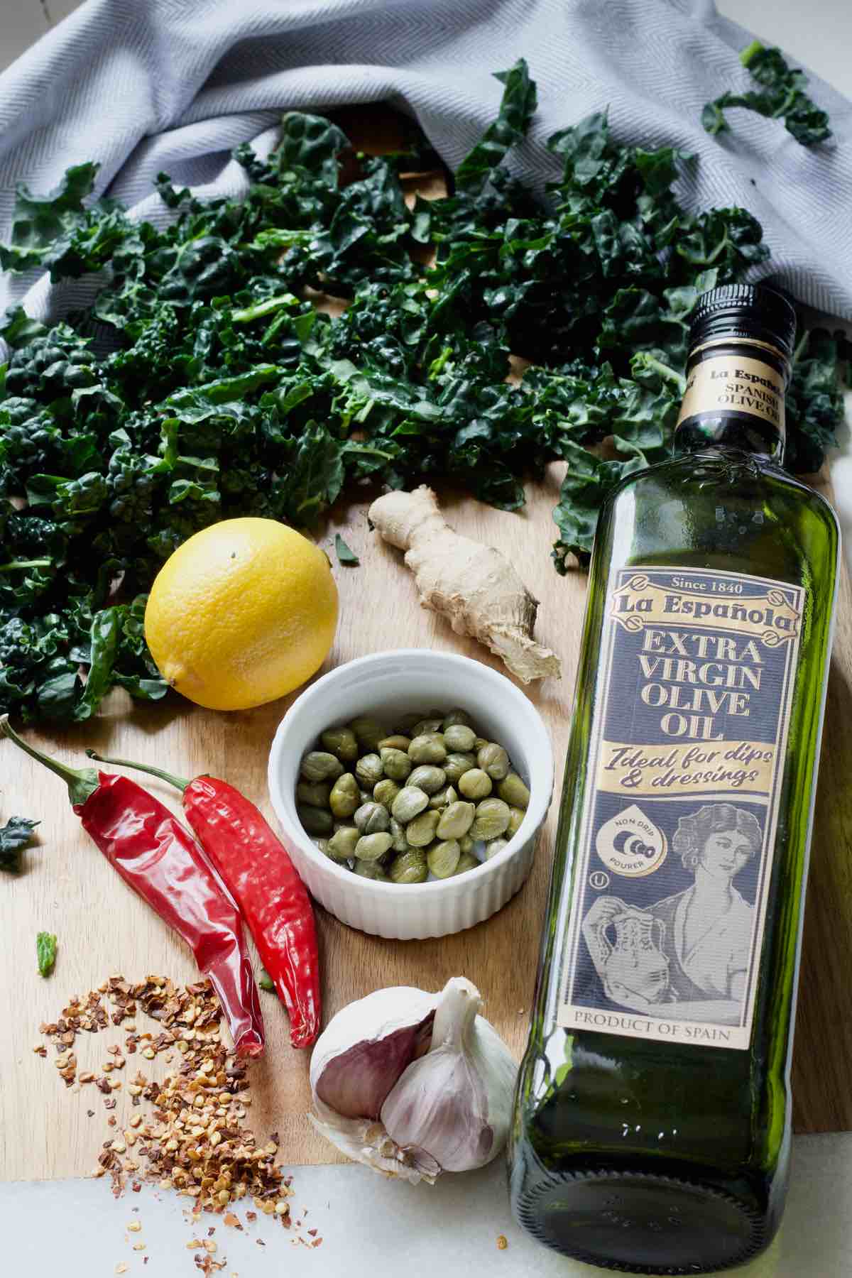 Board with lemon, ginger,capers, chillies, garlic, olive oil and cavolo nero.
