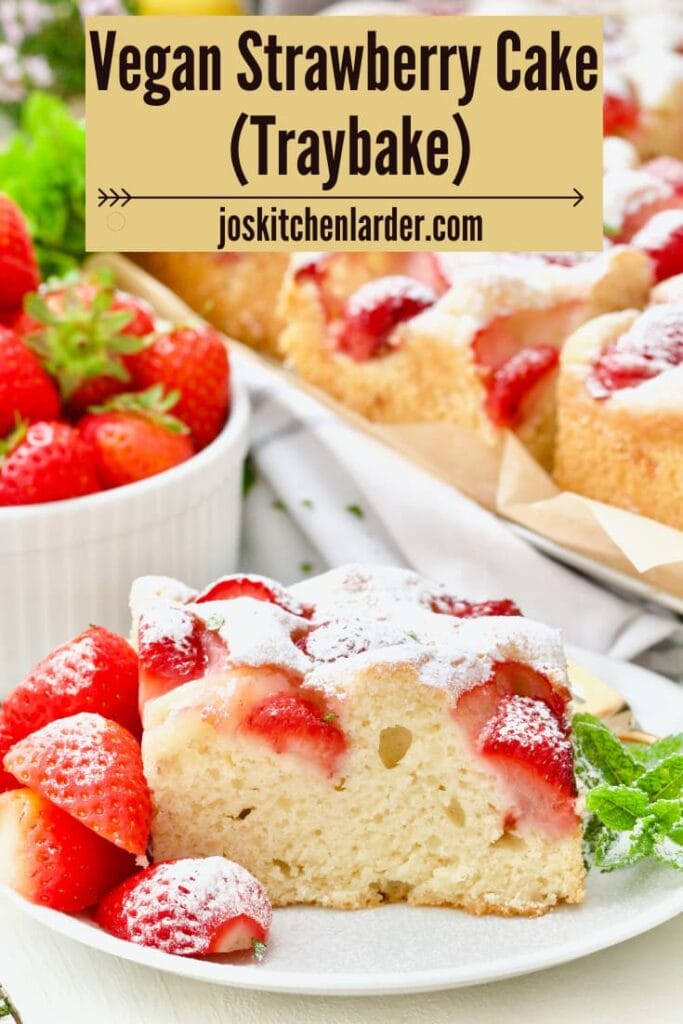 Serving of strawberry cake with whole cake in the background.