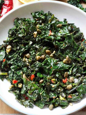 Plate with pan fried black kale, crispy capers, chilli, garlic and lemon.